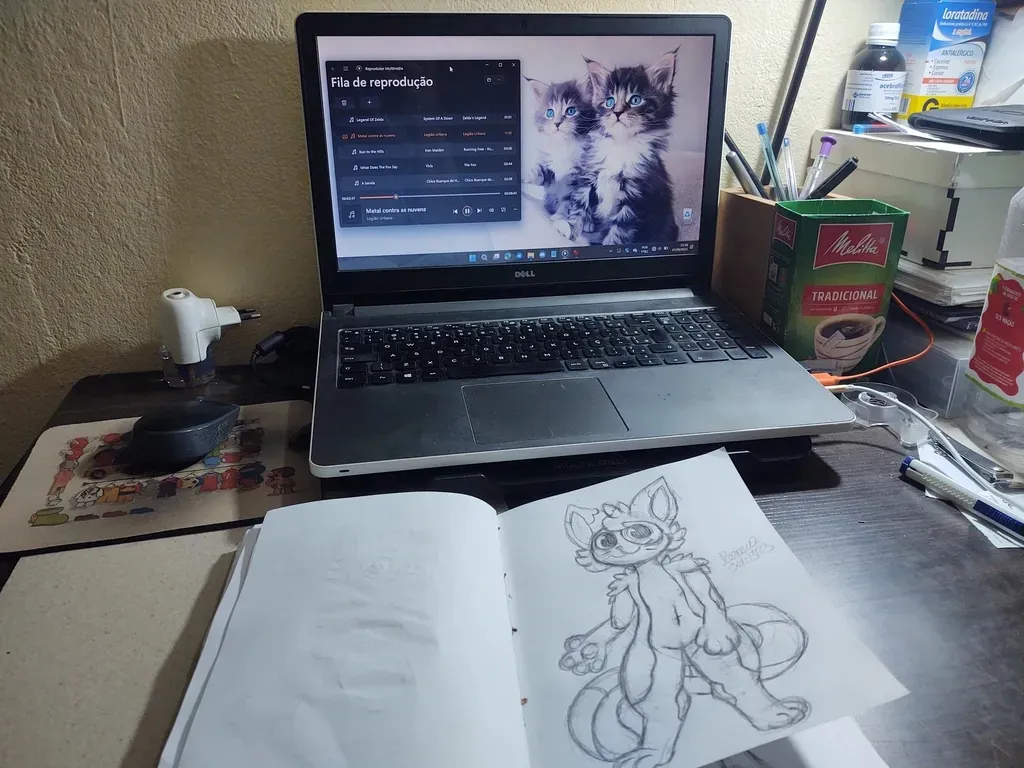 Meu Dell Inspiron 5558 e a bagunça da minha mesa junto com um desenho que eu fiz do Mocha, meu Fursona secundário.